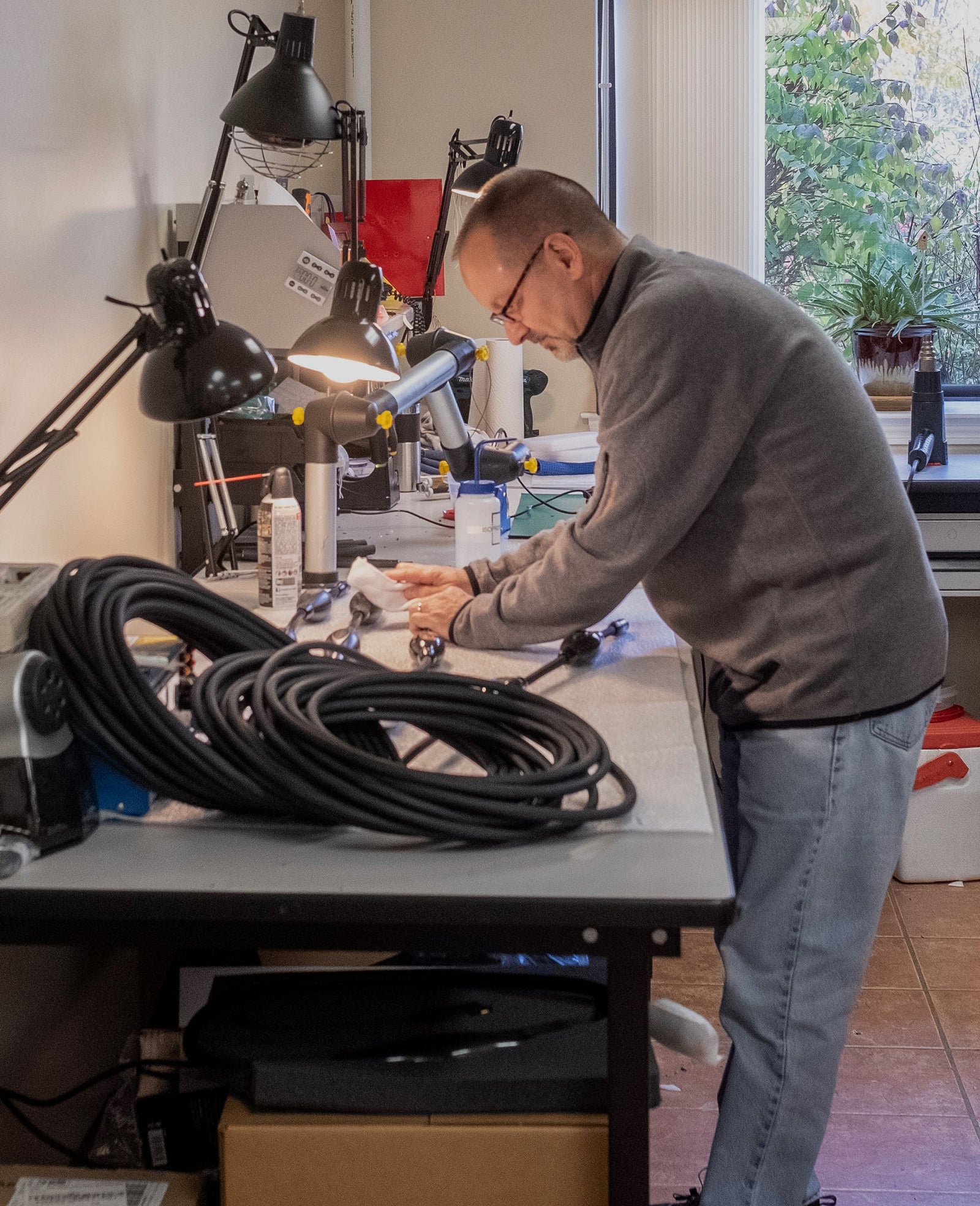 A man working at a desk with a lot of cables.