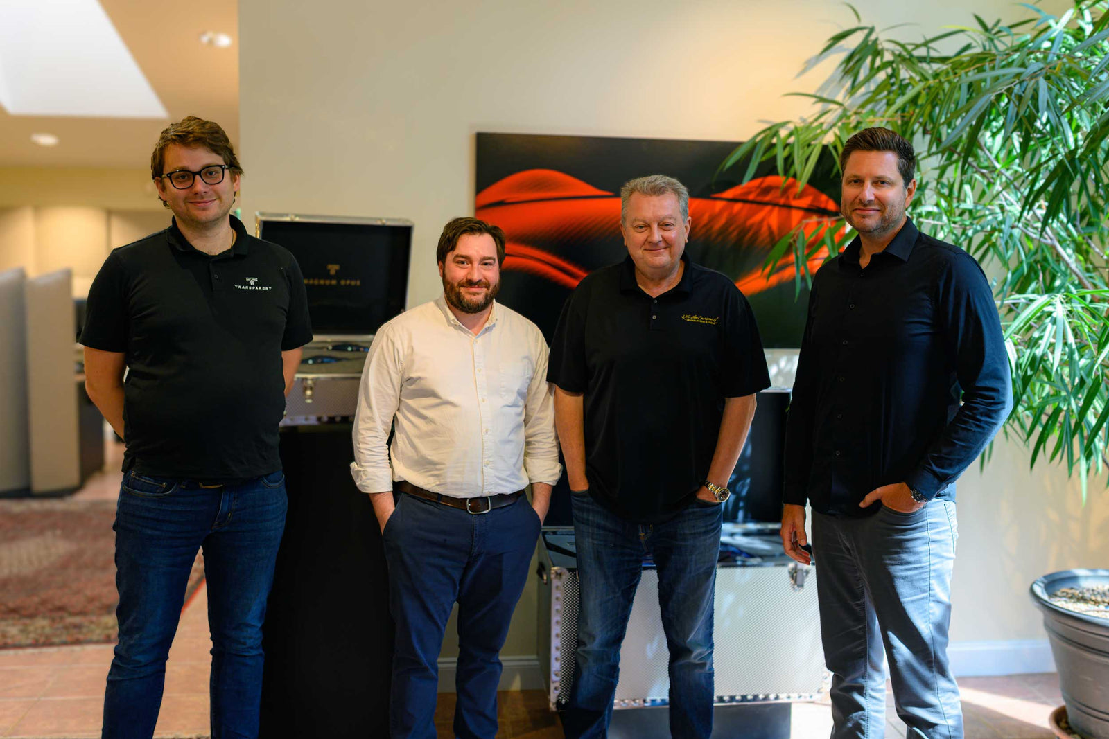 Four men standing in front of a computer.