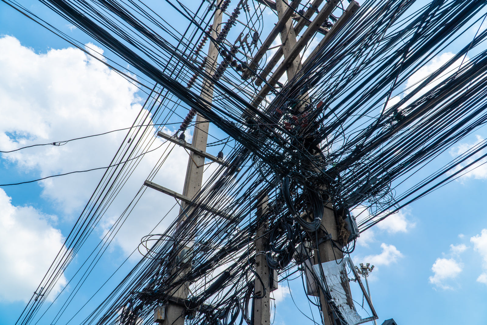 Electrical wires on a pole against a blue sky.