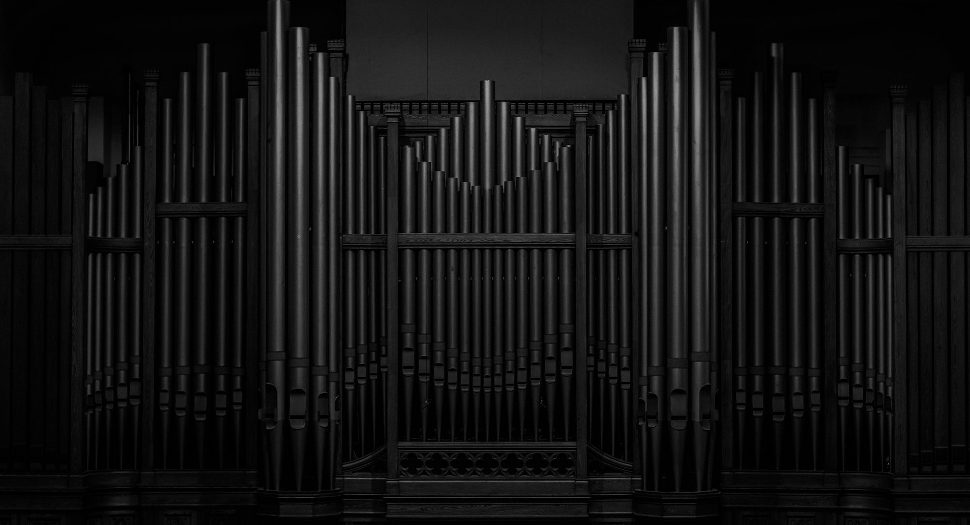 A black pipe organ in a dark room.