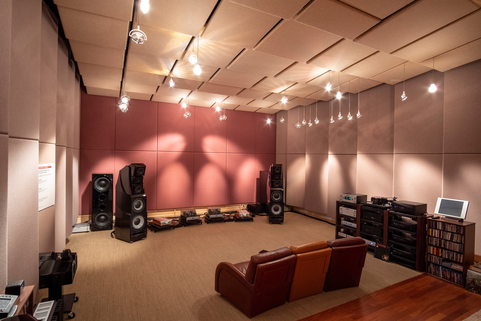 A room with a large number of speakers and a couch.