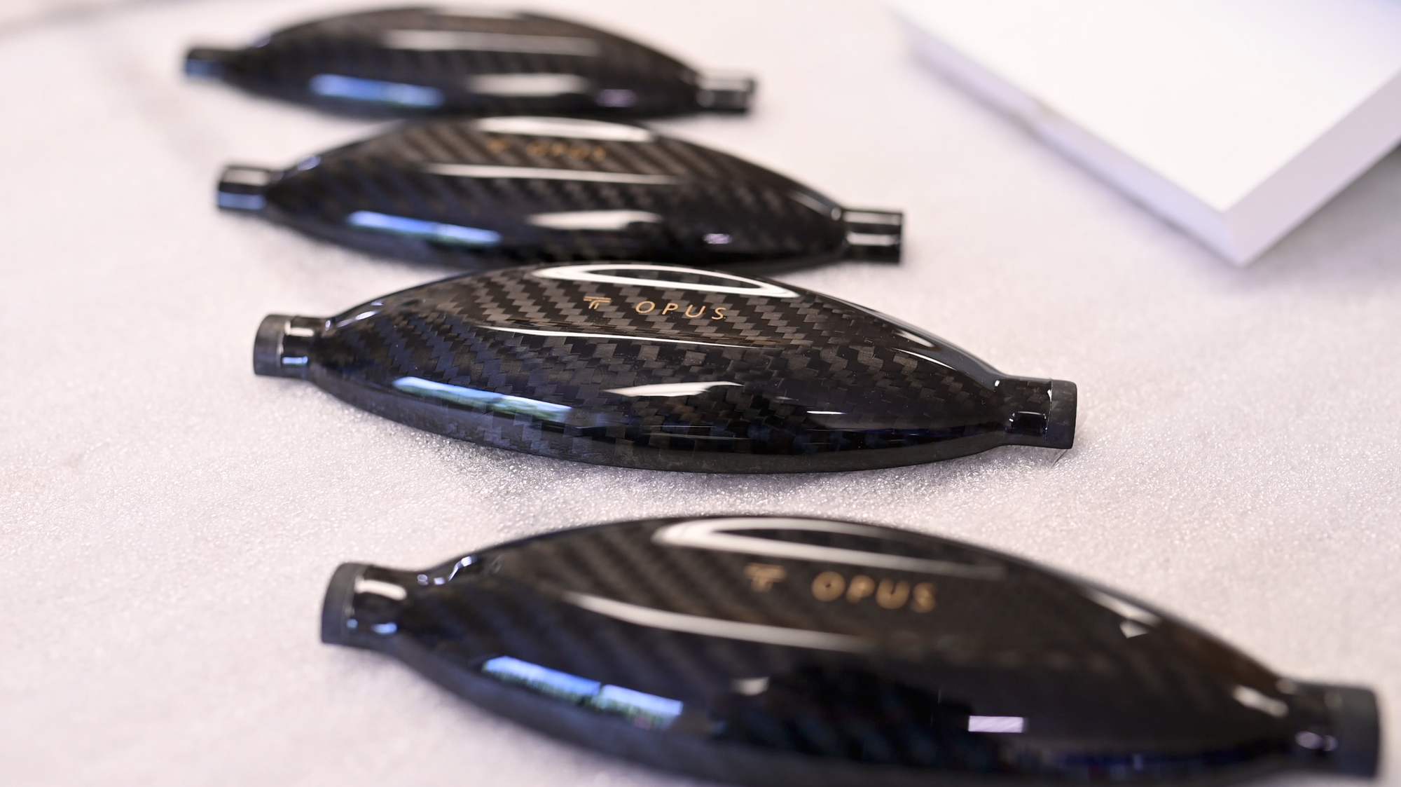 A group of black carbon fiber covers on a table.