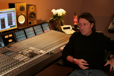 A man sitting in front of a mixing desk.