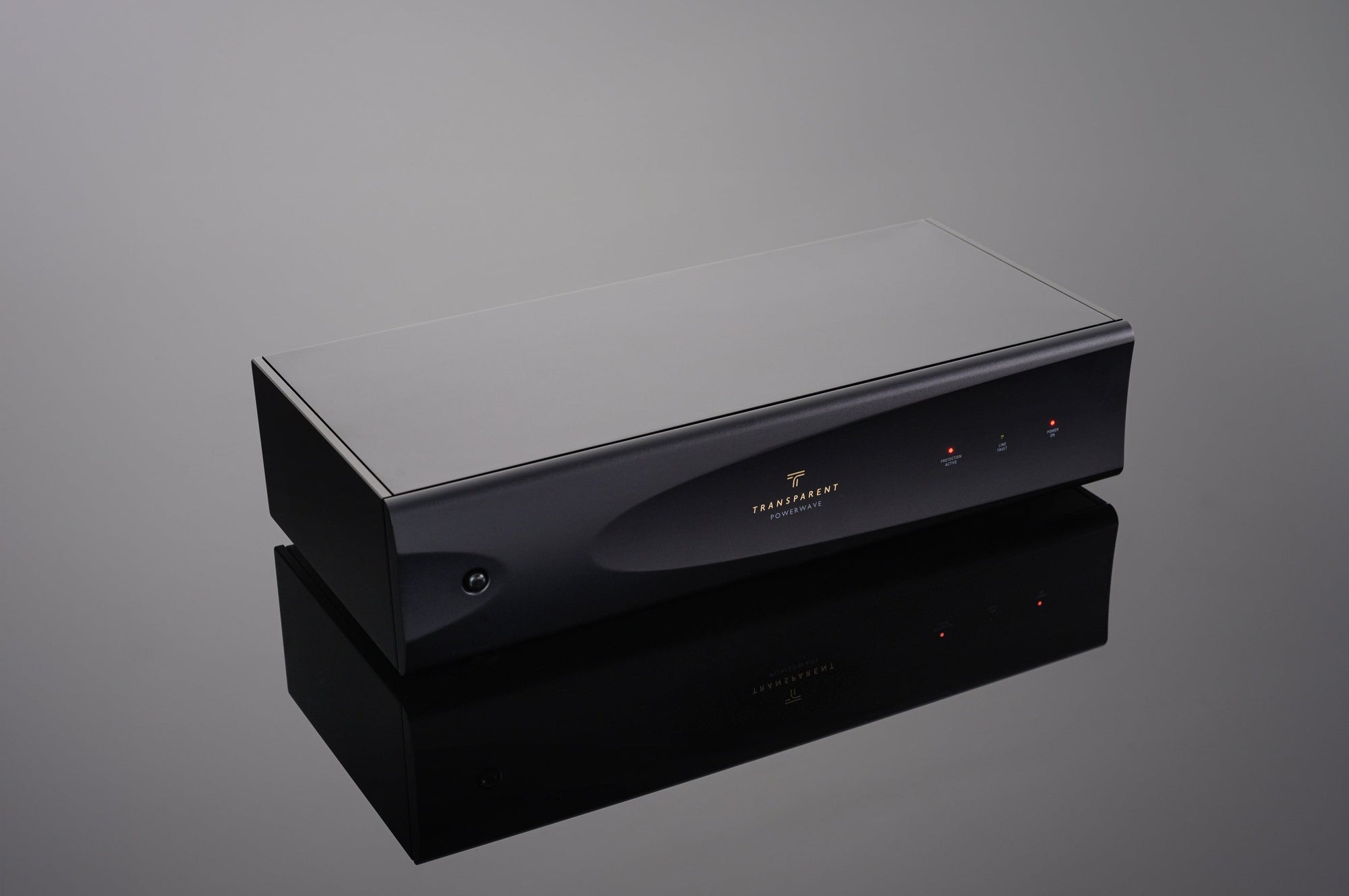 The PowerWave by Transparent Audio, a rectangular black electronic device featuring two indicator lights on the front panel, reflected on a glossy surface, offers noise-free power for your tech.