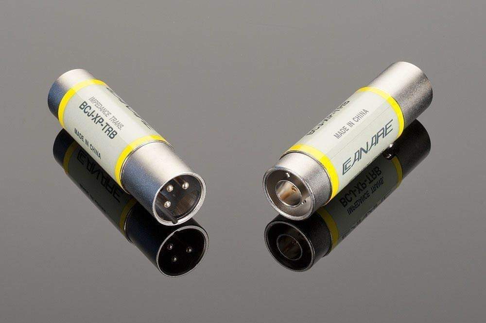 Two metallic XLR connectors branded "Transparent Audio," each adorned with yellow labels—one featuring a 75-Ohm Female BNC and the other a 110-Ohm Male XLR—placed on a reflective surface, essential for high-quality digital audio in home entertainment experiences.