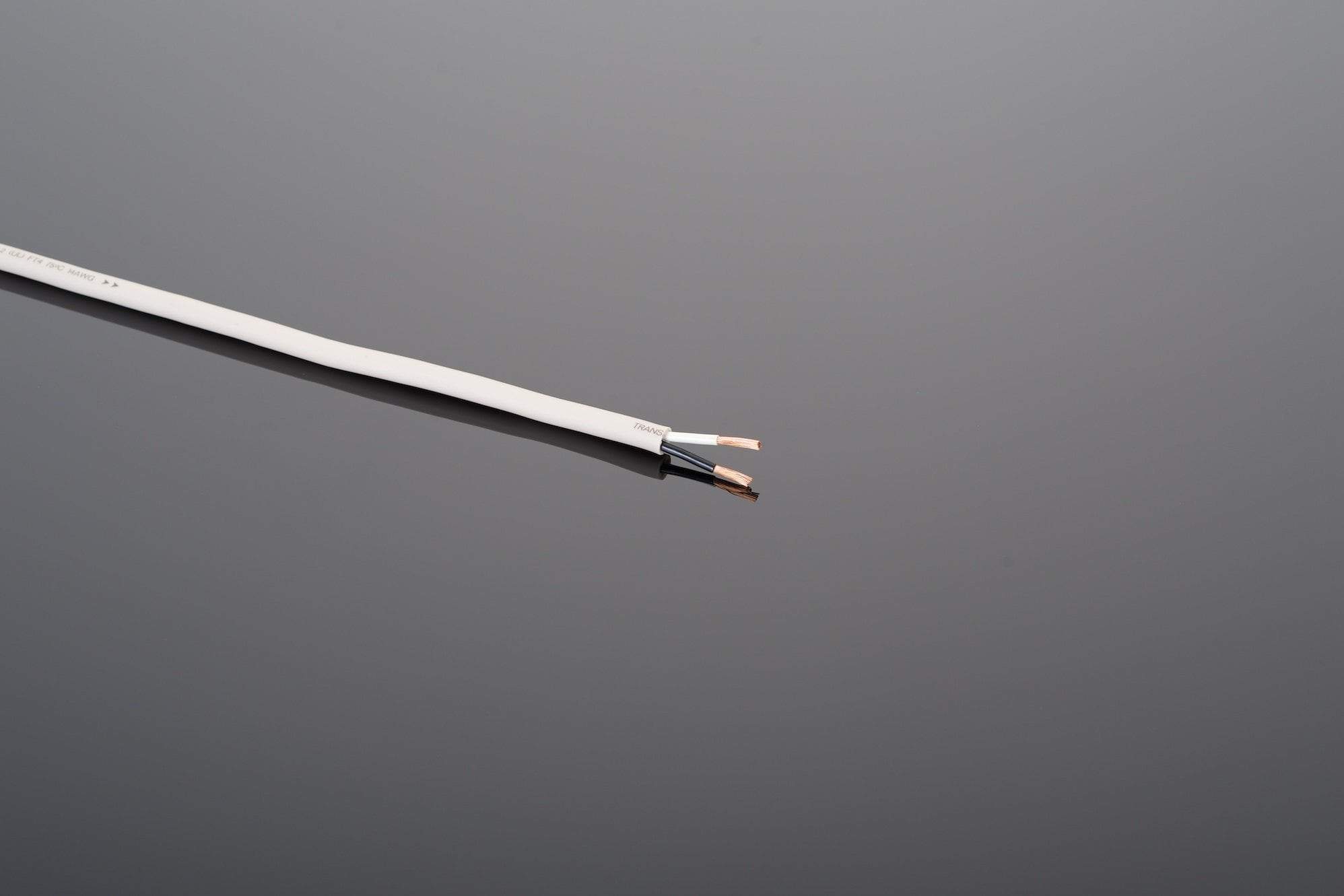 A close-up of a partially stripped white High Performance 14-2 Speaker Cable from Transparent Audio exposes two copper conductors against a plain gray background.