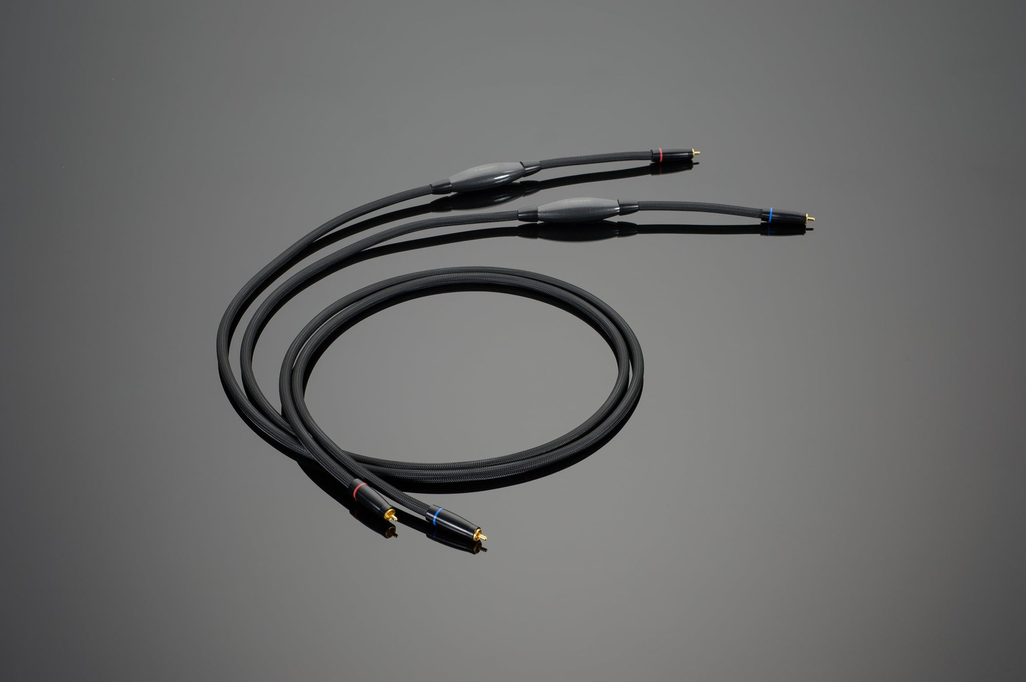Image of a black Transparent Audio REFERENCE RCA Interconnect cable featuring three connectors on each end, designed for connecting audio equipment and ensuring precise low-level information retrieval.