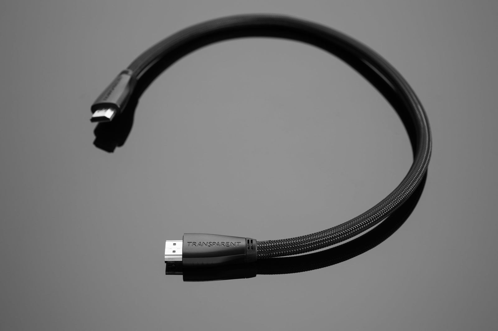 A Transparent HDMI Digital cable by Transparent Audio, coiled on a gray surface, perfect for your music and film system.